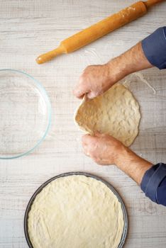 Cooking pizza dough on the kitchen vertical