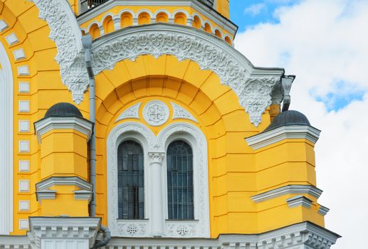 yellow church building with windows and pillars.