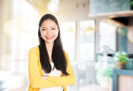 Asian female shop owner arms crossed standing in her cafe. Young woman entrepreneur.