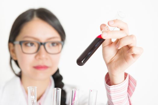 Young Asian laboratory assistant checking the blood in tube, portrait shot of a female scientist.