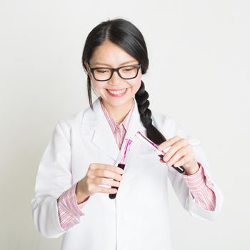 Young female scientist checking the blood in tube.