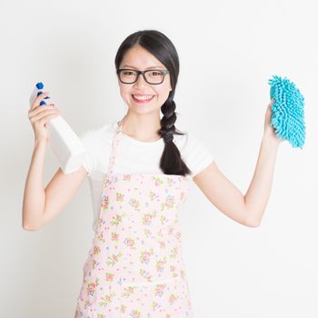 Young Asian woman preparing to do house cleaning. Hand holding detergent spray and microfiber cloth.