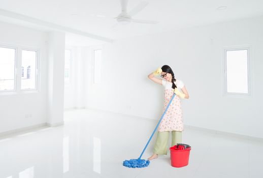 Young Asian woman mopping floor with water, cleaning house.
