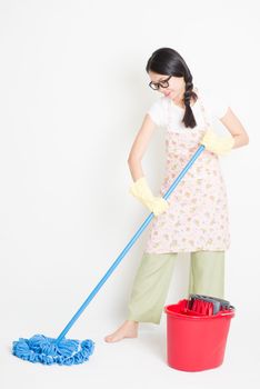 Young Asian housewife mopping floor with water, home cleaning.