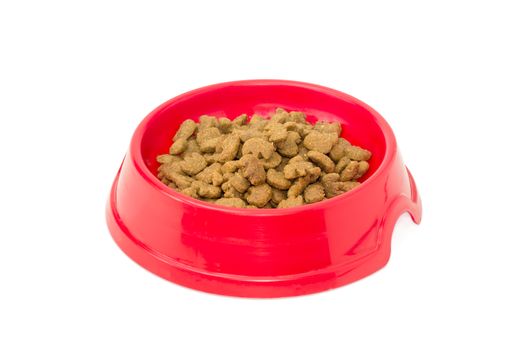 Pelleted dry cat food in a red plastic bowl on a light background
