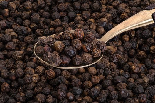 Whole Black Pepper on Old  Brass Spoon