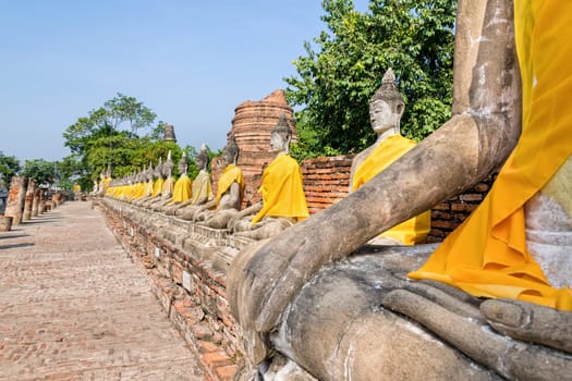 Row of Buddha statue sitting at Wat Yai Chaimongkol temple in Phra Nakhon Si Ayutthaya Historical Park, Ayutthaya Province, Thailand