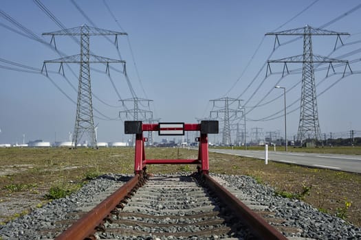 End of the line. A red railway stopper the the end of rusty train track. Port of Rotterdam. The Netherlandds