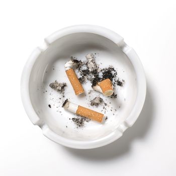 Overhead of old cigarettes in a ashtray on white background