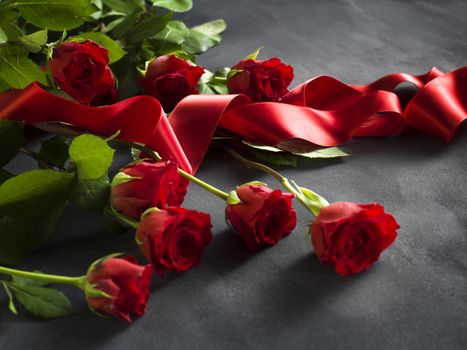 Ribbon and grey stone with a bunch of red roses