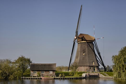 Dutch windmill at Kinderdijk, an UNESCO world heritage site. Stone brick Windmill with water.