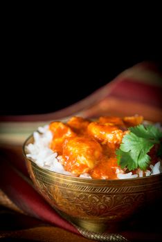 Indian butter chicken served on a bowl of basmati rice.