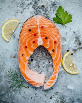 Fresh salmon fillet sliced flat lay on shabby metal background. Raw salmon fillet and ingredients parsley ,fennel ,pepper corn and lemon propose for cooking salmon steak.