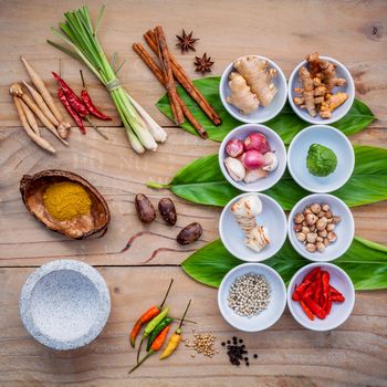 Various of thai food cooking ingredients for spice red curry paste ingredient of thai popular food on galanga leaf background. Spices ingredients chili ,pepper, nutmeg, garlic and Kaffir lime leaves.