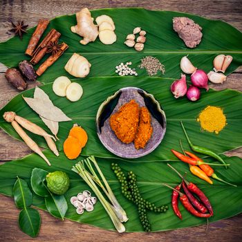 Various of Thai food Cooking ingredients and spice red curry paste ingredient of thai popular food on turmeric leaf background. Spices ingredients chili ,pepper, nutmeg, garlic and Kaffir lime leaves.