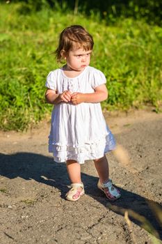 a little girl walks in the Park in summer