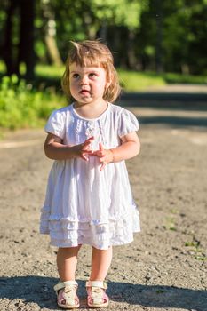 a little girl walks in the Park in summer