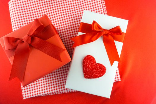 Valentines gift box with a red bow on red background. Image of Valentines day.
