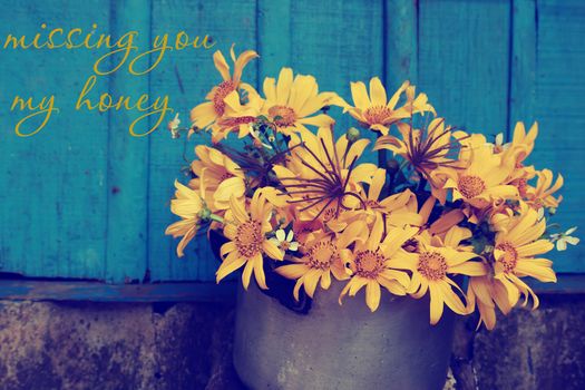 Vintage background with apologize for break up of love, hurt, sorry text and missing, concept from wild sunflower on rustic blue wooden background