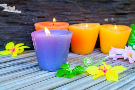 candles and flowers plastic beautiful on bamboo table on old wood background