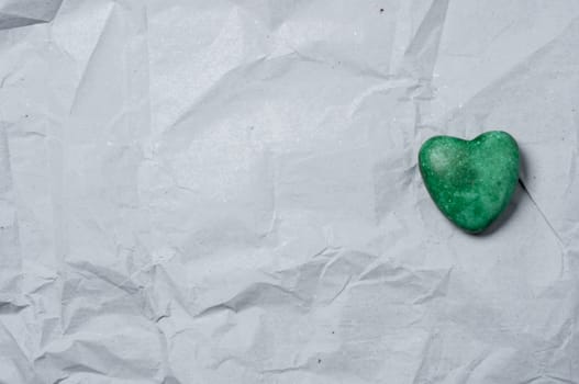 Green heart of stone of a recycled paper.