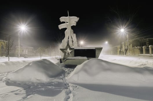 Dimitrovgrad, Ulyanovsk region, Russia on 6 January 2017. Dark city in the fog and a monument in the form of flying cranes. Snow and lights are lit.