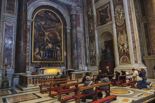 VATICAN ITALY - NOVEMBER 8 : pilgrim sitting on desk with beautiful  interior of st.peter basilica church vatican city on november 8, 2016 in vatican rome italy
