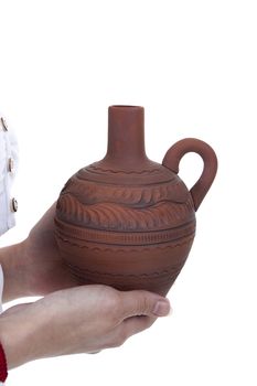 Clay pitcher in female hands on a white background