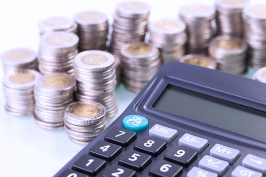 Couns and calculator on white background. Studio shot