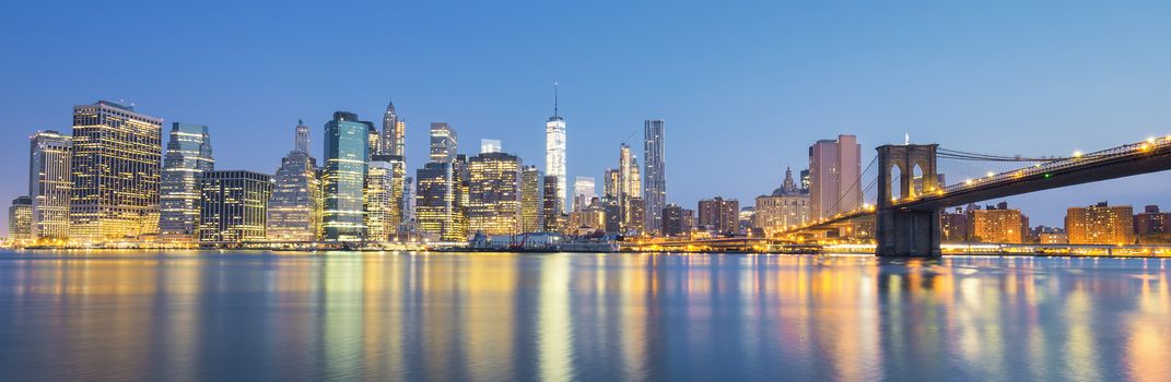 View of New York City Manhattan midtown at dusk with skyscrapers illuminated over east river