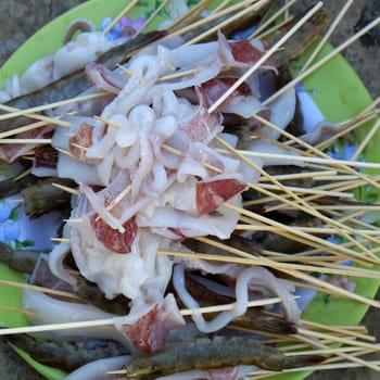 Vietnamese food for weekend party of family at home, cuttlefish and shrimp skewer to grill, delicious seafood