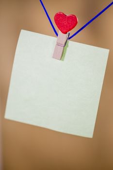 Heart clothes peg holding note with blank copy space