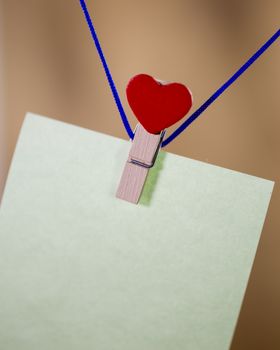 Heart clothes peg holding note with blank copy space