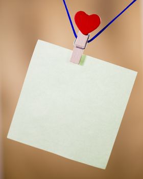 Heart clothes peg holding note with blank copy space