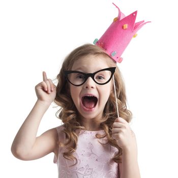 Funny princess girl in pink dress and crown holding party glasses on stick and saying something smart with finger up