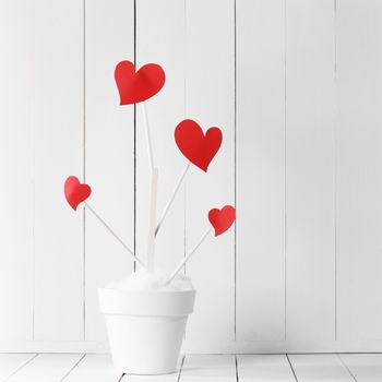Love tree with red heart shaped leaves in white flower pot