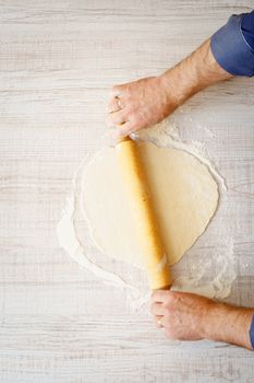 Rolling dough on the white table vertical