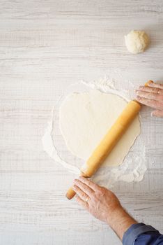 Rolling dough on the wooden table vertical