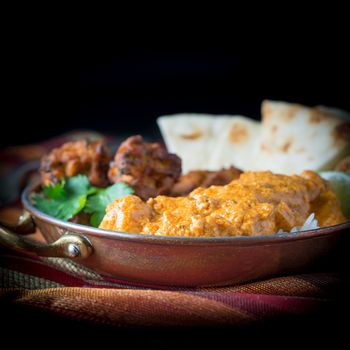 Indian meal consisting of chicken korma, rice, pakoras and nan bread.