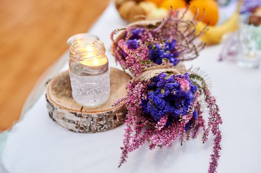 beautiful wedding decor on table with candle and bouquet in rustic style.