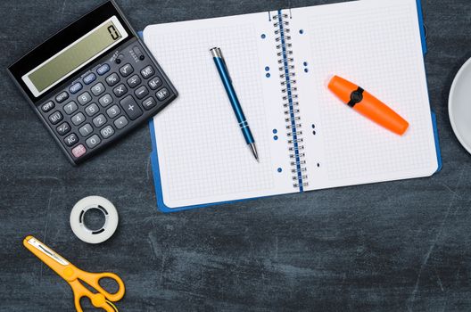 Business desk in office top view. Table with calculator, notepad, and office supplies. Copy space website banner concept