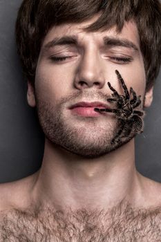 Portrait of a Young Handsome Man with Big Spider on His Face