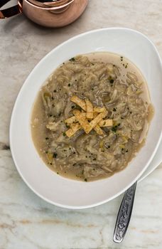 French onion soup with croutons in a white oval modern dish