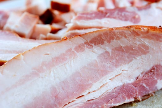 Closeup of bacon slices on cutting board.