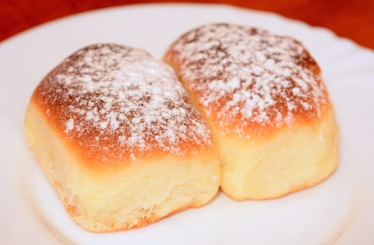 Sweet baked homemade buns powdered with sugar.