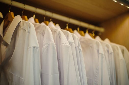 background of row of white shirt hanging in closet