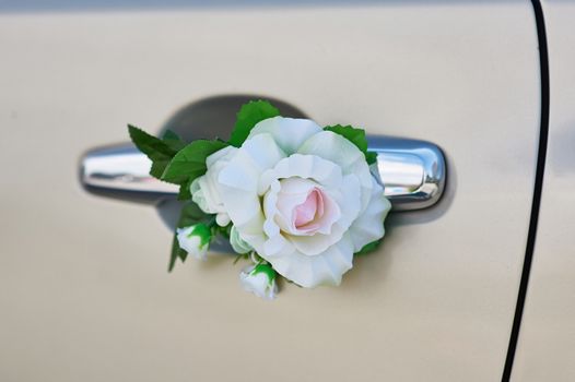 white rose flower on the handle of a car in wedding day.