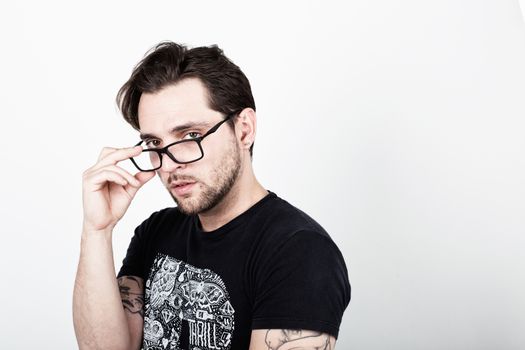 An attractive young man with glasses on white background looking at the camera