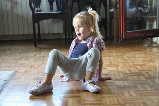 Cute young girl playing on the floor