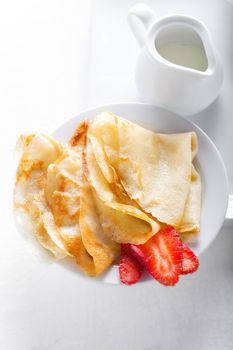 Crepes with strawberries on a white background